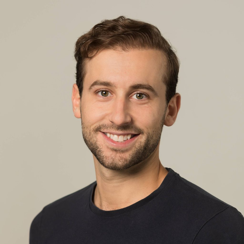 Bruno is a white man with short light-brown hair and a beard smiling at the camera