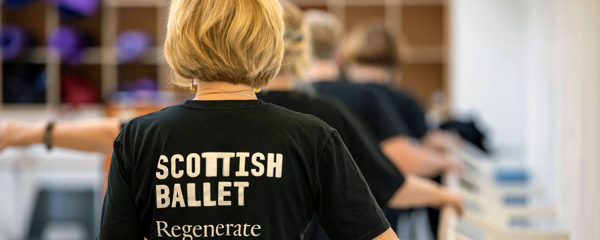 Back view of an older dancer standing in a studio