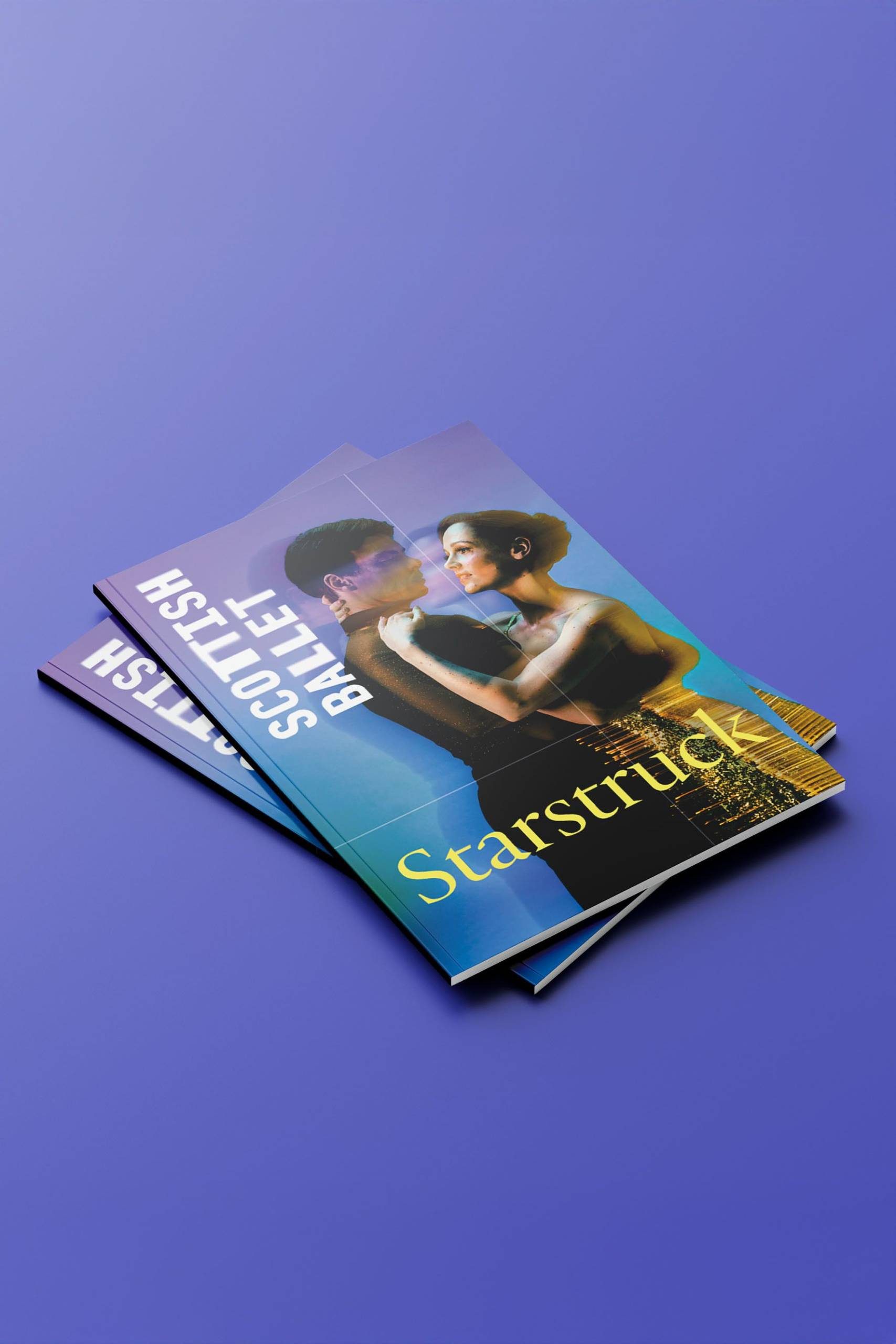 Two stacked Scottish Ballet programmes on a purple surface feature a cover image of two dancers embracing, with the title Starstruck in yellow letters.